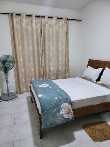 - une chambre avec un lit et une fenêtre avec un ventilateur dans l'établissement JADO House, à Dakar