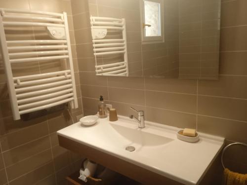 une salle de bain avec un lavabo blanc et un miroir dans l'établissement Mas en pierres sèches avec piscine, à Lussan