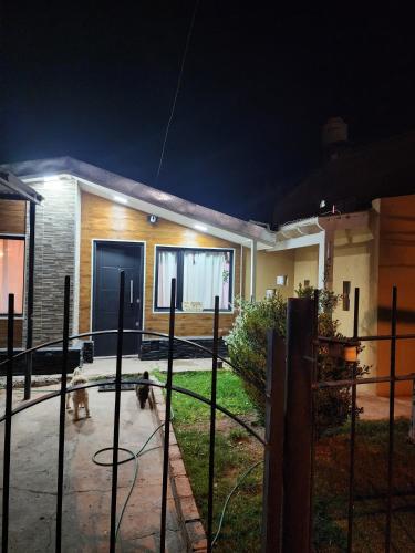 un perro parado frente a una casa por la noche en Rincon house en Rincón de los Sauces