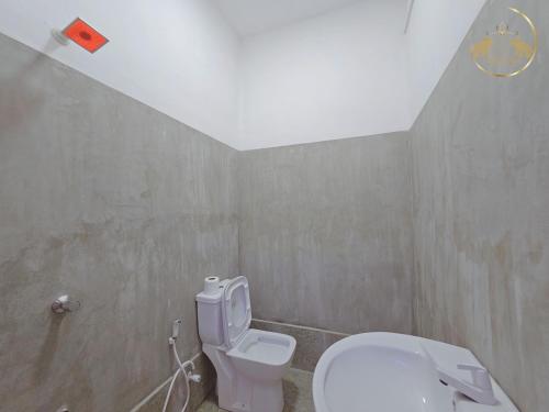 ein Bad mit einem weißen WC in einem Zimmer in der Unterkunft Galle Face Terrace Hostel by Tourlux in Colombo