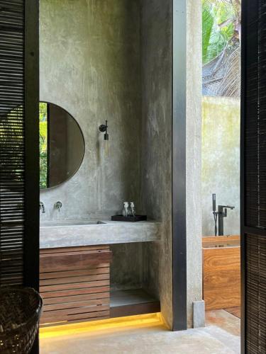 a bathroom with a sink and a mirror at KAJU GREEN eco lodges in Unawatuna