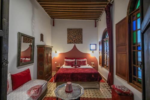 フェズにあるRiad Les Idrissides Chez LEAのベッドルーム(赤いベッド1台、ソファ付)