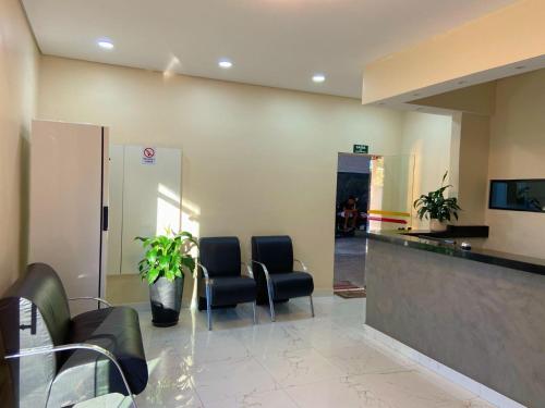 a waiting room with two chairs and a counter at Hotel Flex Tatuapé in Sao Paulo