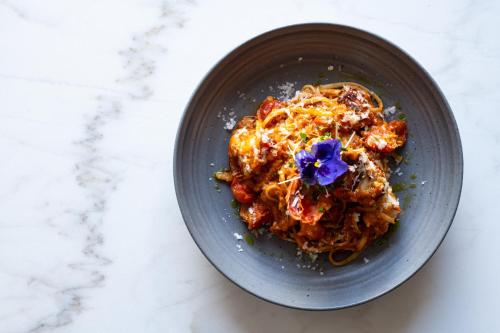 a bowl of pasta with a purple flower on it at The Neela Boutique Hotel Stone Town in Zanzibar City