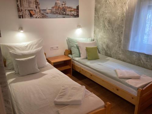 two twin beds in a room with at Tünde Vendégház in Tiszakécske