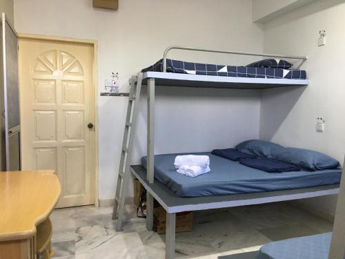 a bunk bed in a room with a ladder at Thian Siong Inn in Melaka