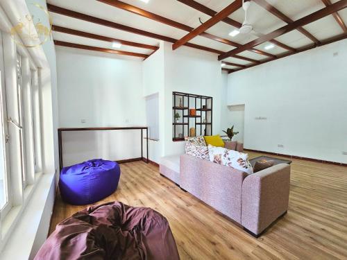 a living room with a couch and a large window at Galle Face Terrace Hostel by Tourlux in Colombo