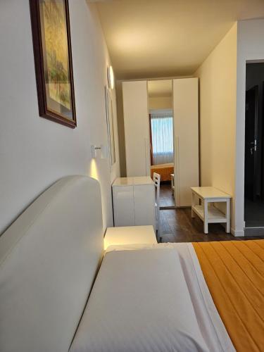 a white bedroom with a bed and a table at Victoria Royal Garden in Como