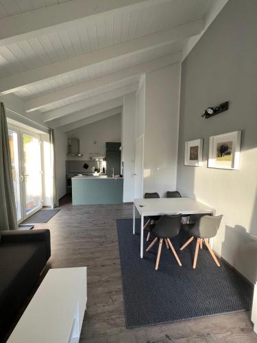 a living room with a white table and chairs at Ferienhaus Auszeit mit Sauna in Schwarz