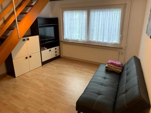 a living room with a couch and a television at Ferienwohnung Röder in Osterode