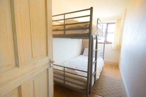 Pokój z 2 łóżkami piętrowymi i drzwiami w obiekcie Swifts Retreat w mieście Buxton