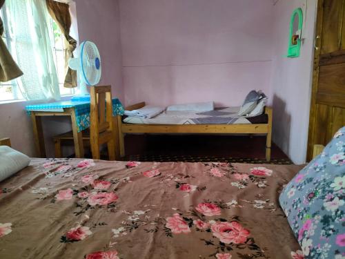 ein Schlafzimmer mit einem Bett mit Blumen auf dem Boden in der Unterkunft SCENIC HOMESTAY in Cherrapunji