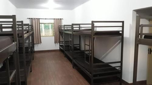 a room with three bunk beds and a window at RECANTO OJAMA in Abadiânia