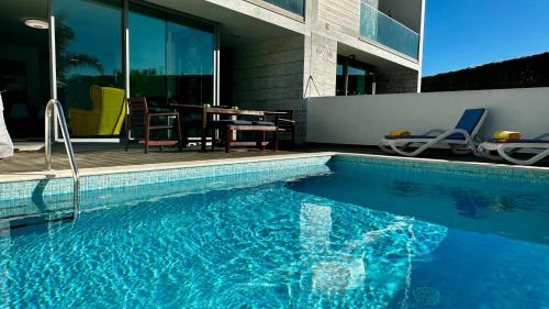 Una piscina con una mesa y sillas al lado de una casa. en Moon by Check-in Portugal, en Albufeira