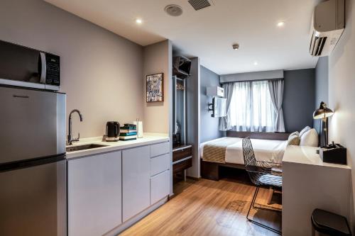 a small room with a kitchen and a bed at Heritage Collection on Clarke Quay - A Digital Hotel in Singapore