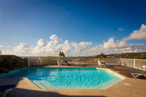 a swimming pool with a view of the ocean at Studio magnifique vue sur mer in Saint Martin
