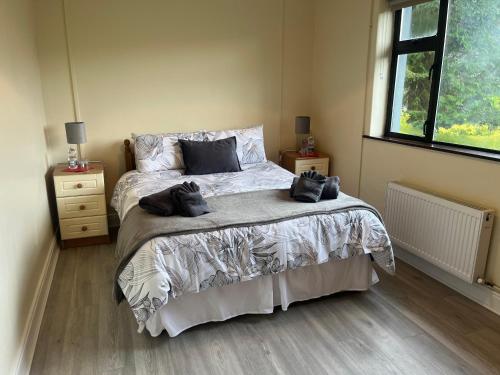 um quarto com uma cama com duas toalhas pretas em An Cnoc em Killorglin