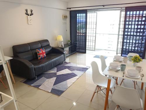 sala de estar con sofá de cuero negro y mesa en [Georgetown] 2~6 Pax, 3 Bedrooms, 1 Car Park, en Jelutong
