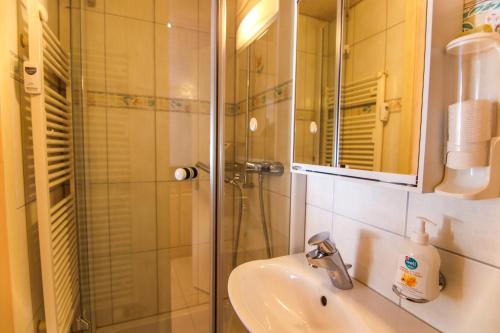a bathroom with a sink and a shower at Paultina by Arosa Holiday in Arosa