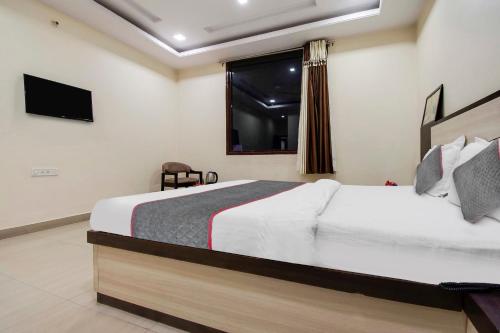 een slaapkamer met een groot bed en een raam bij Capital O Hotel Pink Peral in Jaipur