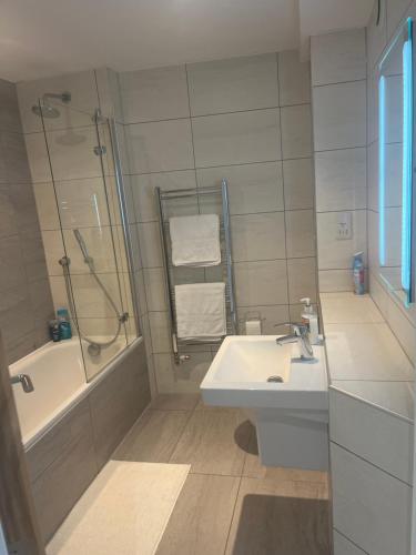 a white bathroom with a sink and a shower at Huller and cheese warehouse apartments in Bristol