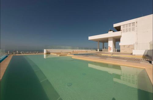 un edificio con una piscina de agua frente a un edificio en ESPECTACULAR APARTAMENTO PISO ALTO CON EXCELENTE VISTA AL MAR y A LA CIUDAD AMURALLADA, en Cartagena de Indias