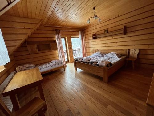 Un dormitorio con una cama en una cabaña de troncos en Domek na Stasince, en Sidzina