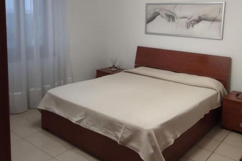 1 dormitorio con 1 cama grande con sábanas blancas en JanaHome - Affitti Brevi Pisa, en Pisa