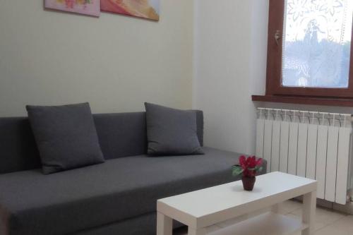 sala de estar con sofá gris y mesa blanca en JanaHome - Affitti Brevi Pisa, en Pisa