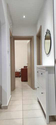 baño con tocador y espejo en la pared en JanaHome - Affitti Brevi Pisa, en Pisa