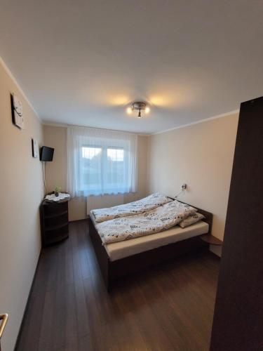 1 dormitorio con cama y ventana. en Eplényi Apartmanház, en Eplény