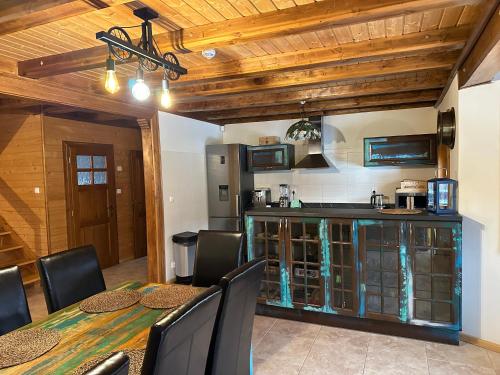 cocina con mesa, sillas y barra en Przystanek Beskidy, en Brenna