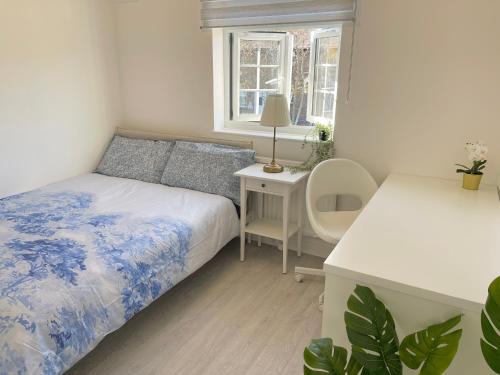 a bedroom with a bed and a desk with a chair at Big Shadwell House Close Station and Tower Bridge in London