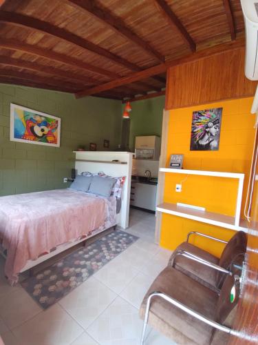 a bedroom with a bed and a yellow wall at Tiny House Perfeita para Casais in Florianópolis