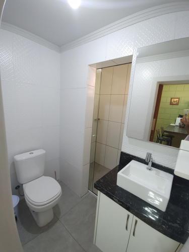 a white bathroom with a toilet and a sink at Tiny House Perfeita para Casais in Florianópolis