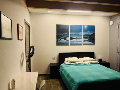 a bedroom with a bed with three paintings on the wall at Villa di Carlone in Moscufo