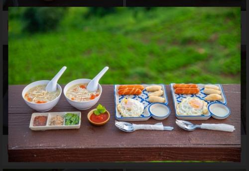 Mon Jam的住宿－ฮักวิว ม่อนแจ่ม，餐桌,盘子上放着食物和碗