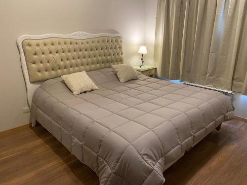 a bedroom with a large bed with a large headboard at Casa Las Margaritas II in San Carlos de Bariloche