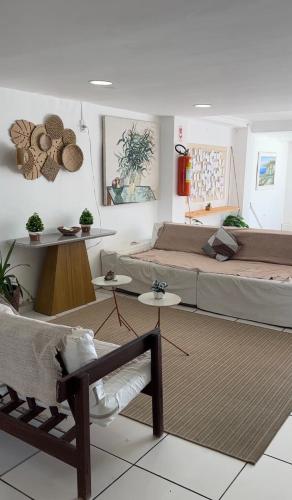 a bedroom with two beds and a bench in it at Pousada Seven in Arraial do Cabo