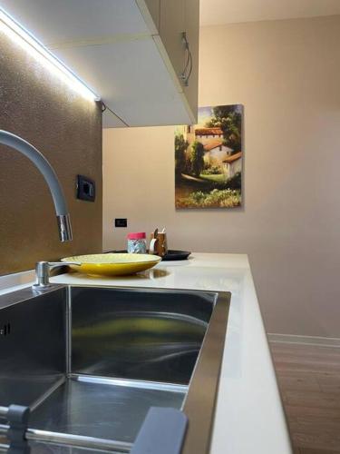 Eine Küche mit Spüle und einem gelben Teller auf der Arbeitsfläche. in der Unterkunft Studio near US Embassy with balcony in Tirana