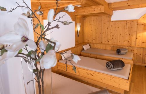 a sauna with a bench and a vase of flowers at Auenhotel in Tux