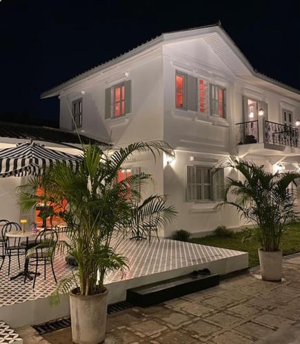 a white house with tables and chairs in front of it at Fides Boutique Hotel in Luang Prabang
