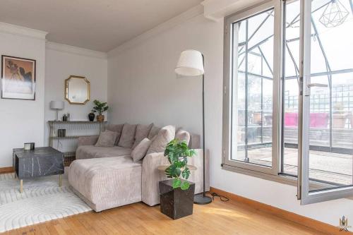 un salon avec un canapé et une grande fenêtre dans l'établissement Magnificient Terrace 6 pers flat, à Paris