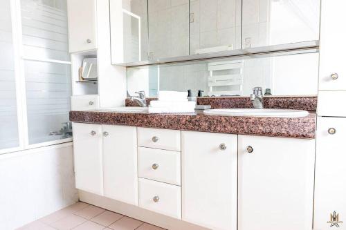 une salle de bain blanche avec deux lavabos et un miroir dans l'établissement Magnificient Terrace 6 pers flat, à Paris