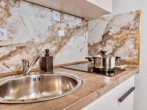 cocina con fregadero y fogones con olla en NEUES Apartment in Top Lage, free Parking max 1,65m Höhe und 1,8m Breite, en Karlsruhe