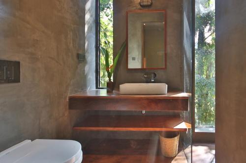 Yatiyantota的住宿－River Pavilion, Kitulgala，一间带水槽和镜子的浴室