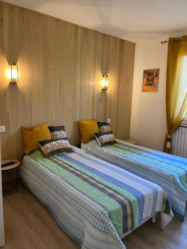 2 Betten nebeneinander in einem Zimmer in der Unterkunft la grande Vadrouille in La Salvetat