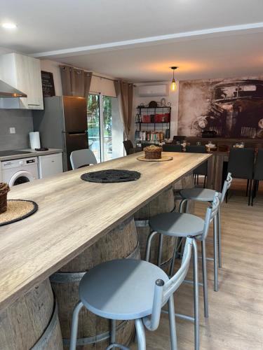 une cuisine avec un grand comptoir et des tabourets dans l'établissement la grande Vadrouille, à La Salvetat-sur-Agout