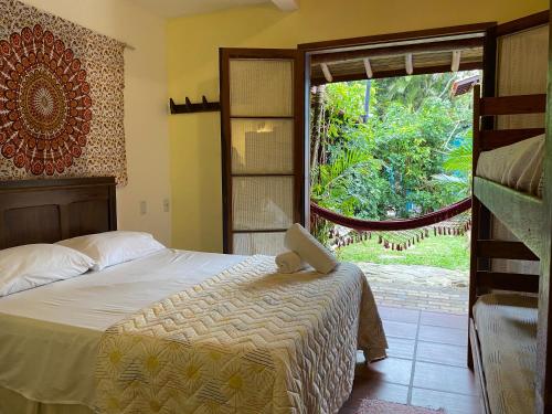 1 dormitorio con cama y ventana grande en Pousada Paradise Ferrugem, en Garopaba