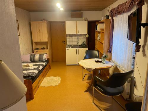 代斯特尔山麓巴德明德尔Ferienwohnung Hoffmann的小房间设有一张床和一张桌子及椅子